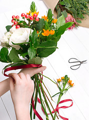 Image showing Female florist making beautiful bouquet at flower shop