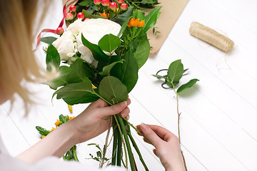 Image showing Female florist making beautiful bouquet at flower shop