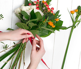 Image showing Female florist making beautiful bouquet at flower shop