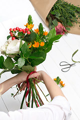 Image showing Female florist making beautiful bouquet at flower shop