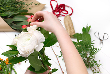 Image showing Female florist making beautiful bouquet at flower shop