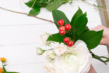 Image showing Female florist making beautiful bouquet at flower shop