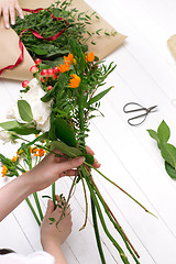 Image showing Female florist making beautiful bouquet at flower shop