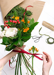 Image showing Female florist making beautiful bouquet at flower shop