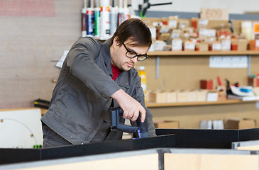 Image showing assembler with screwdriver making furniture