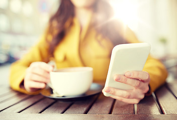 Image showing close up of woman texting on smartphone at cafe