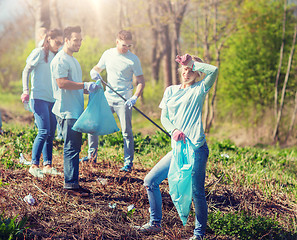 Image showing volunteers with garbage bags cleaning park area