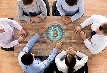 Image showing business team at table with bitcoin icon