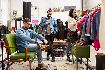 Image showing friends choosing clothes at vintage clothing store