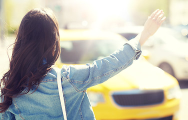 Image showing young woman or girl catching taxi on city street