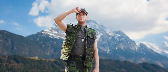 Image showing soldier in military uniform over mountains