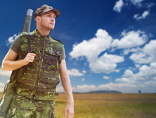 Image showing young soldier or hunter with gun over savannah