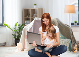 Image showing happy mother with little daughter and laptop