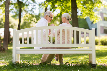 Image showing happy senior couple sitting on bench at park