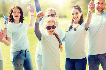 Image showing group of volunteers celebrating success in park