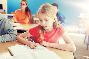 Image showing student girl with book writing school test