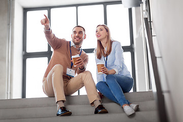 Image showing man and woman with conference badges drink coffee