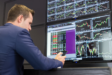 Image showing Stock trader looking at market data on computer screens.