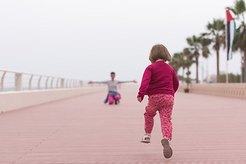 Image showing mother and cute little girl on the promenade by the sea