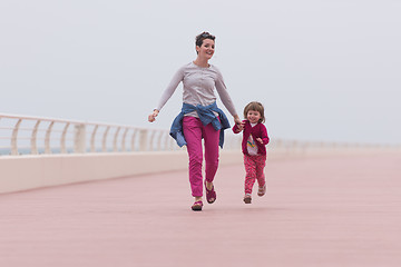 Image showing mother and cute little girl on the promenade by the sea