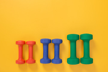 Image showing Dumbbells of different colors and sizes
