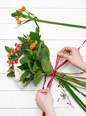 Image showing Female florist making beautiful bouquet at flower shop