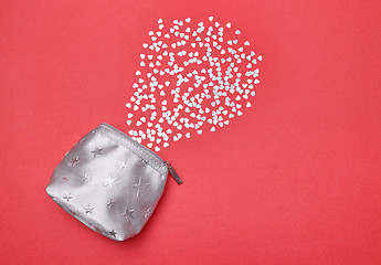 Image showing Shiny silver hearts and purse on pink background