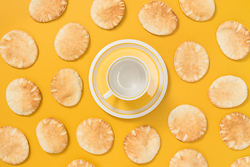 Image showing Teacup and pita bread on yellow background