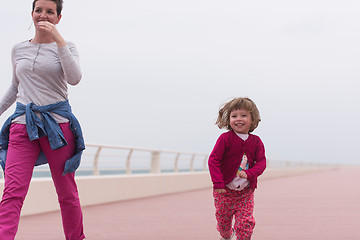 Image showing mother and cute little girl on the promenade by the sea