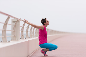 Image showing woman stretching and warming up on the promenade