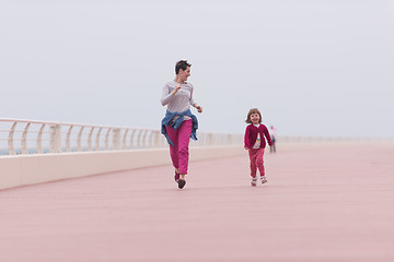 Image showing mother and cute little girl on the promenade by the sea