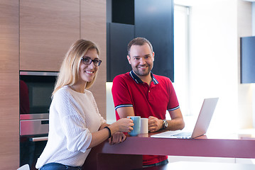 Image showing couple drinking coffee and using laptop at home