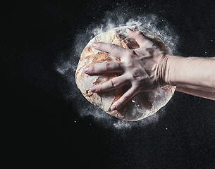 Image showing Closeup of male hands put fresh bread on black background with copy space for your text