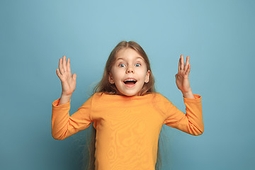 Image showing The surprise, happiness, joy, victory, success and luck. Teen girl on a blue background. Facial expressions and people emotions concept