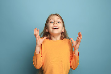 Image showing The surprise, happiness, joy, victory, success and luck. Teen girl on a blue background. Facial expressions and people emotions concept