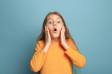 Image showing The surprise, happiness, joy, victory, success and luck. Teen girl on a blue background. Facial expressions and people emotions concept