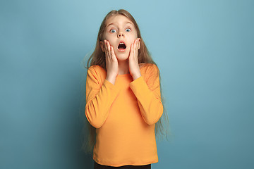 Image showing The surprise, happiness, joy, victory, success and luck. Teen girl on a blue background. Facial expressions and people emotions concept