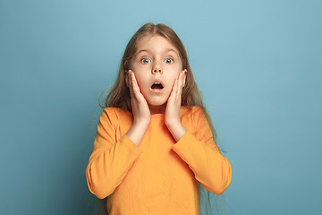 Image showing The surprise, happiness, joy, victory, success and luck. Teen girl on a blue background. Facial expressions and people emotions concept