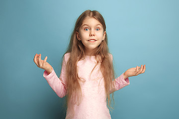 Image showing The surprise, happiness, joy, victory, success and luck. Teen girl on a blue background. Facial expressions and people emotions concept