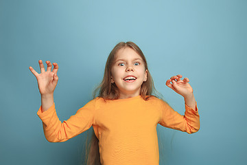 Image showing The surprise, happiness, joy, victory, success and luck. Teen girl on a blue background. Facial expressions and people emotions concept