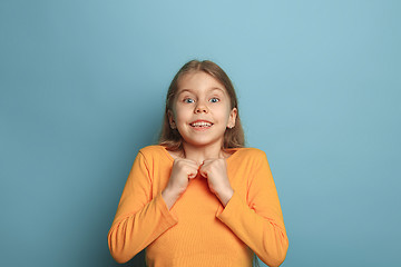 Image showing The surprise, happiness, joy, victory, success and luck. Teen girl on a blue background. Facial expressions and people emotions concept