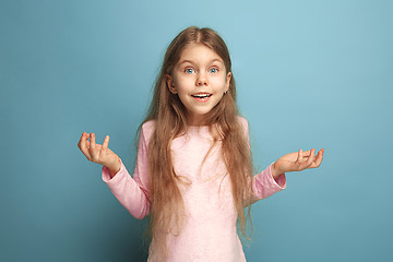 Image showing The surprise, happiness, joy, victory, success and luck. Teen girl on a blue background. Facial expressions and people emotions concept