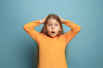 Image showing The surprise, happiness, joy, victory, success and luck. Teen girl on a blue background. Facial expressions and people emotions concept