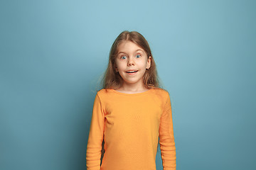 Image showing The surprise, happiness, joy, victory, success and luck. Teen girl on a blue background. Facial expressions and people emotions concept