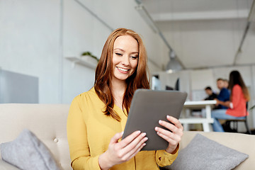 Image showing redhead woman with tablet pc working at office