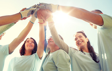 Image showing group of volunteers making high five outdoors