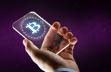 Image showing hand with smartphone and bitcoin hologram