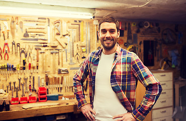 Image showing happy young workman in checkered shirt at workshop