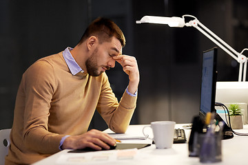 Image showing tired businessman working at night office