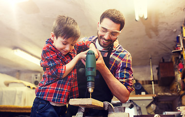 Image showing father and son with drill working at workshop